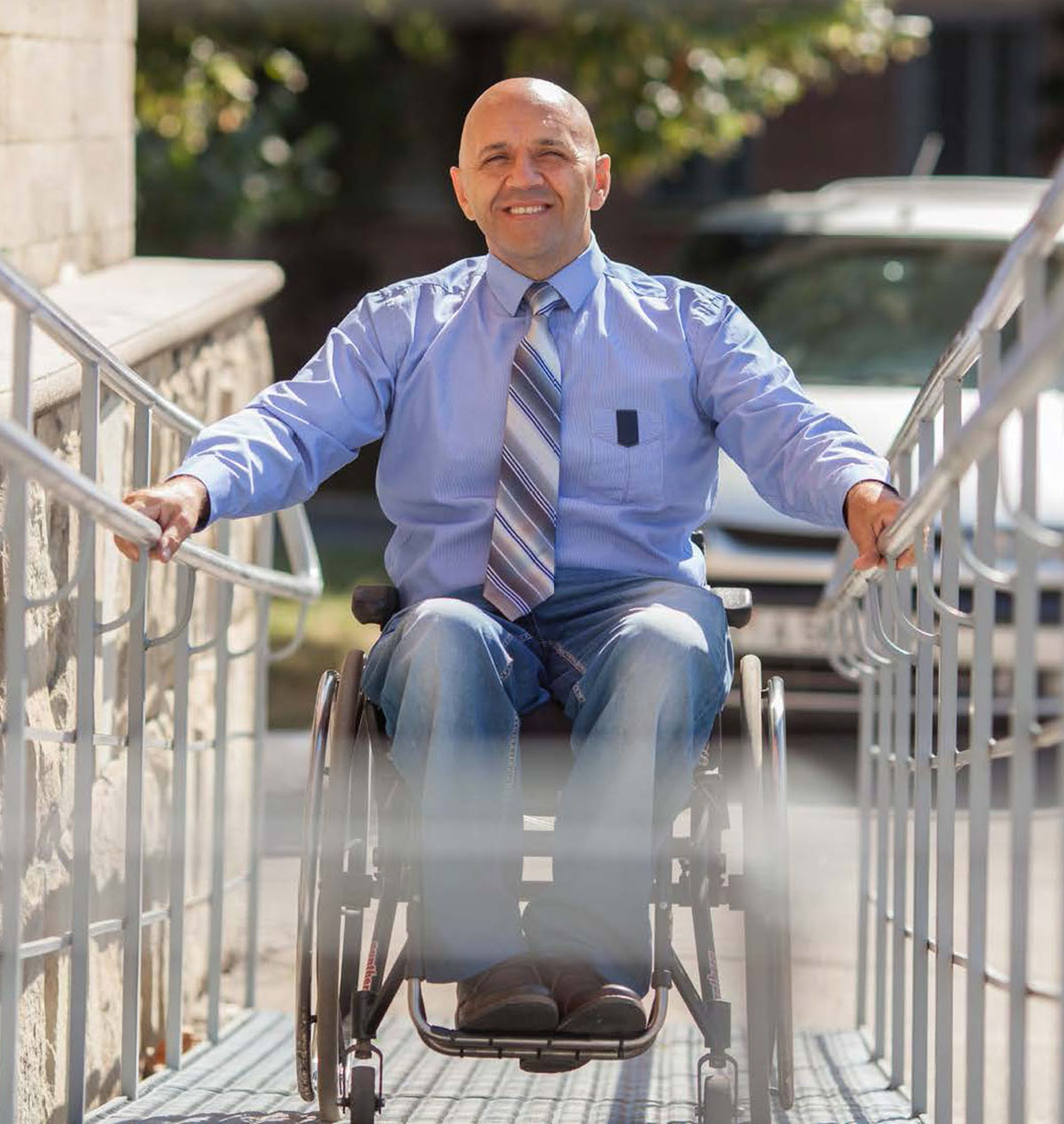 Man using the wheelchair ramp to enter the building