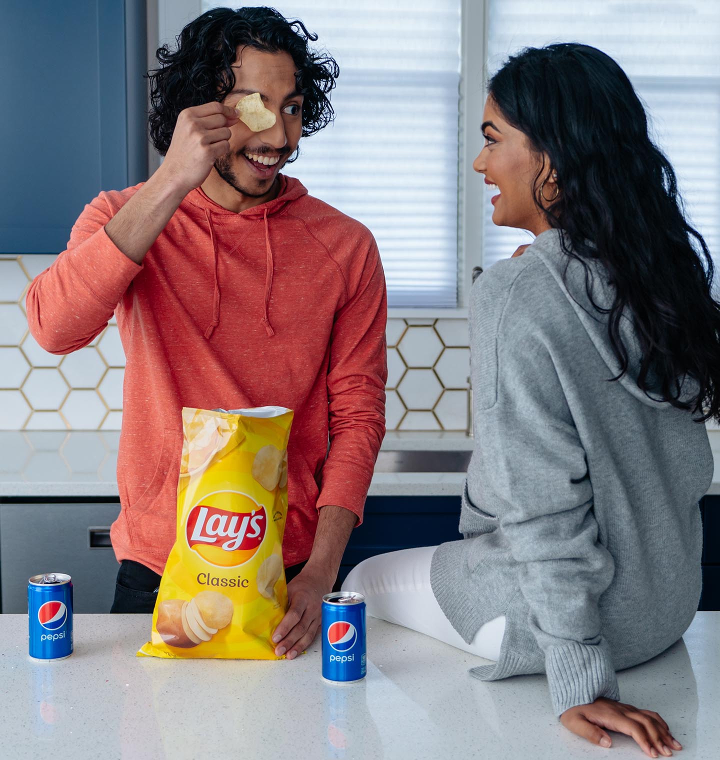 Friends sharing a laugh over chips & soda